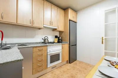 a kitchen with wooden cabinets and a stainless steel refrigerator at Vincent's House in Barcelona