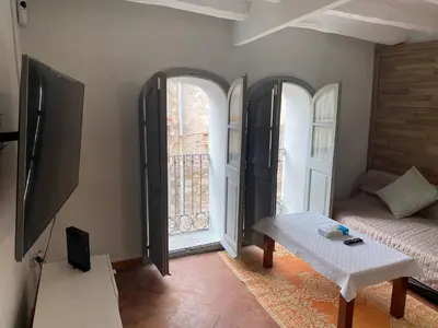 a living room with a couch and two large windows at Piso Rustico Calle de la Font Vilafranca del penedes in Vilafranca del Penedès