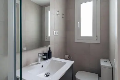 a bathroom with a sink and a mirror and a toilet at Casa Atrio - Wonderful studio near Barcelona cathedral in Barcelona