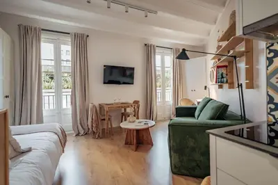 a living room with a green couch and a table at Casa Atrio - Wonderful studio near Barcelona cathedral in Barcelona