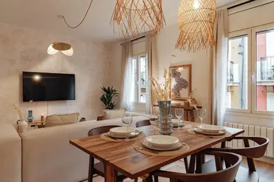 a living room with a table and a couch at Casa Calders in Barcelona