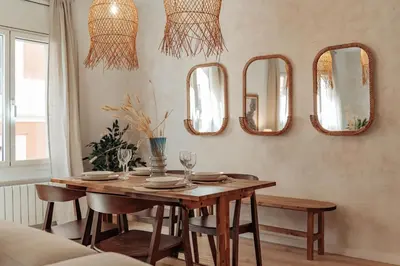 a dining room table with mirrors on the wall at Casa Calders in Barcelona