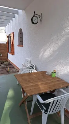 a wooden table with white chairs and a clock on the wall at La Garsa in Aiguafreda