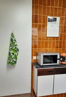 a kitchen with a microwave and a calendar on the wall at La Garsa in Aiguafreda