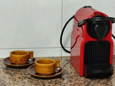 two cups on plates next to a coffee maker at Ca La Dulcet in Gélida