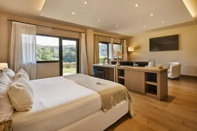 a bedroom with a bed and a desk with a sink at Mas Salagros EcoResort & SPA in Vallromanas