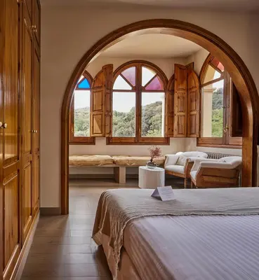 a bedroom with a bed and two windows at Mas Salagros EcoResort & SPA in Vallromanas