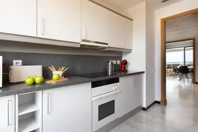 a kitchen with white cabinets and a counter top at Lets Holidays Apartment Sea Views in Barcelona in Barcelona