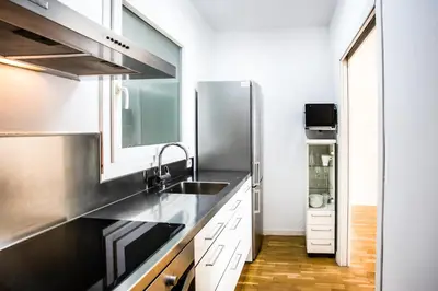 a kitchen with a sink and a refrigerator at Suitur apartamento exclusivo céntrico Barcelona in Barcelona