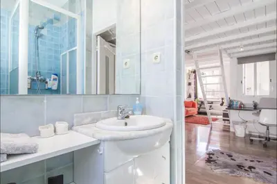 a white bathroom with a sink and a mirror at Terrace Duplex at Sagrada Familia by PriorityVillas in Barcelona