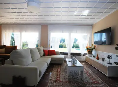 a living room with a white couch and a tv at Torre Vendrell con Padel in Sant Pere de Vilamajor