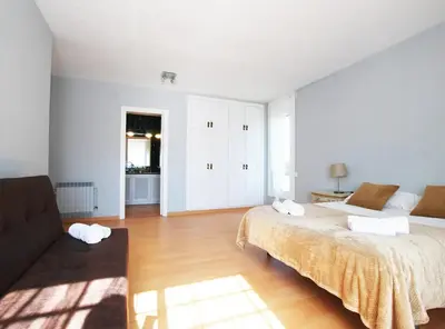 a white bedroom with a bed and a couch at Torre Vendrell con Padel in Sant Pere de Vilamajor