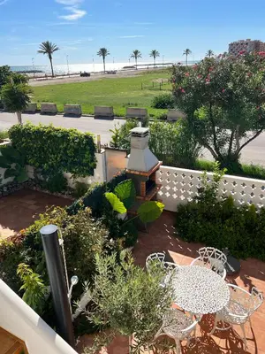 a garden with a table and chairs and a fence at Espectacular Sunny House in the beach in Cunit
