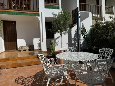 a patio with a table and chairs in front of a building at Espectacular Sunny House in the beach in Cunit