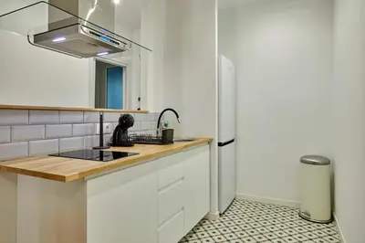 a kitchen with white cabinets and a sink at Stylish typical BCN flat in Barcelona