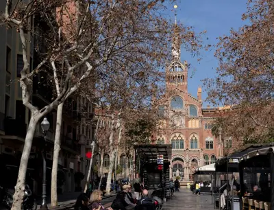 people sitting on a bench in front of a building at Apartamento Gaudí-Sant Pau in Barcelona