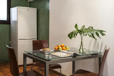 a table with a plate of fruit and a refrigerator at AinB Las Ramblas-Guardia Apartments in Barcelona