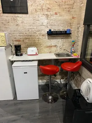 a kitchen with two red stools at a counter at Room not shared center liceu ramblas plaza Cataluña in Barcelona