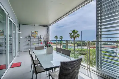 a dining room with a table and chairs and a large window at Seafront suite with terrace in Barcelona