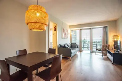 a dining room with a table and a living room at Seafront suite with terrace in Barcelona