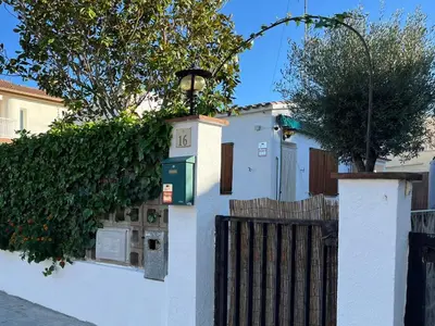 a white house with a fence and a tree at Holiday Beach Home Rincón del Mar in Cunit