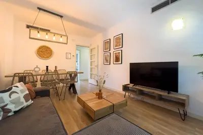 a living room with a large television and a table at The Lonely Chimney Apartments in Barcelona