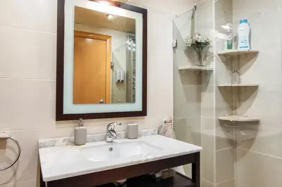 a white bathroom with a sink and a mirror at Fee4Me Comfortable flat near the sea in Sant Adria de Besos