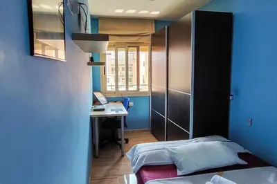 a bedroom with a bed and a desk in a room at Fee4Me Comfortable flat near the sea in Sant Adria de Besos