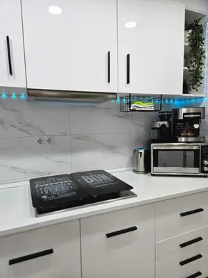 a kitchen with white cabinets and a microwave at Apartamento Moderno, amplio y muy cómodo in Terrassa