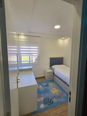 a small bedroom with a bed and a blue rug at Apartamento Moderno, amplio y muy cómodo in Terrassa