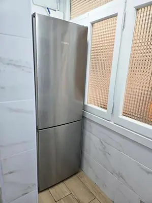 a stainless steel refrigerator in a room with two windows at Apartamento Moderno, amplio y muy cómodo in Terrassa