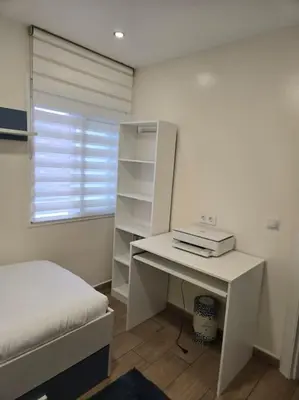 a bedroom with a bed and a desk with a laptop at Apartamento Moderno, amplio y muy cómodo in Terrassa
