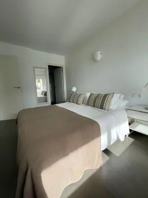 a white bedroom with a large bed and a window at Viva Sitges - Sitges View in Sitges