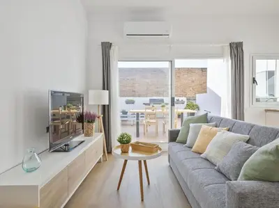a living room with a couch and a table at La Terraza de Badalona in Badalona