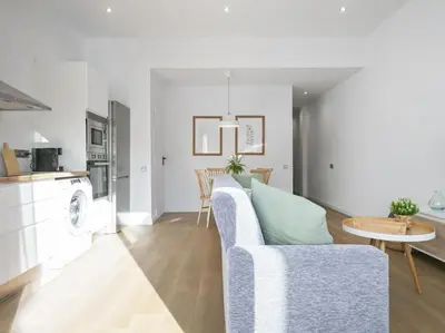a living room and kitchen with a couch and a table at La Terraza de Badalona in Badalona