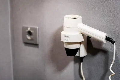 a white blow dryer hanging on a wall at AS Porta de Barcelona in Castellbisbal