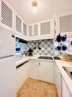 a kitchen with white cabinets and white appliances at Solaui in Esplugues de Llobregat