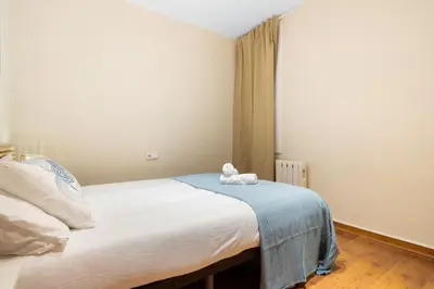 a bedroom with a bed with a stuffed animal on it at Lodging Apartments Entenca in Barcelona