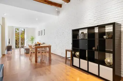 a dining room and living room with a dining table at Lodging Apartments Entenca in Barcelona