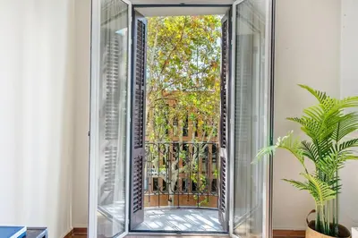 a mirror in front of a window with a gate at Lodging Apartments Entenca in Barcelona