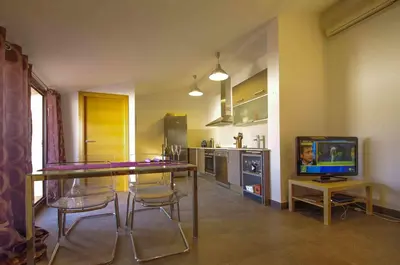 a kitchen with a table and chairs and a television at Matarolux 1 in Mataró
