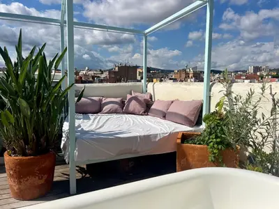 a bed on a balcony with plants and a bath tub at Outdoor Bathtub! 360 Rooftop with Chill Out and Amazing Views! in Barcelona