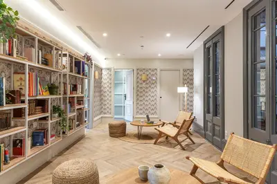 a living room with bookshelves and a table and chairs at Weflating Boutique Hostel in Barcelona
