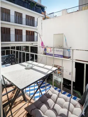 a table and chairs on the balcony of a building at Casa Rainbow by Hello Homes Sitges in Sitges