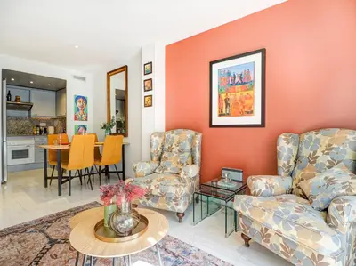 a living room with two chairs and a table at Casa Rainbow by Hello Homes Sitges in Sitges