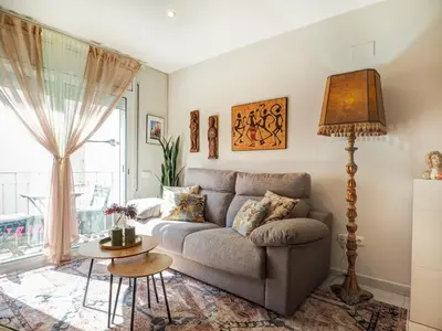 a living room with a couch and a table at Casa Rainbow by Hello Homes Sitges in Sitges