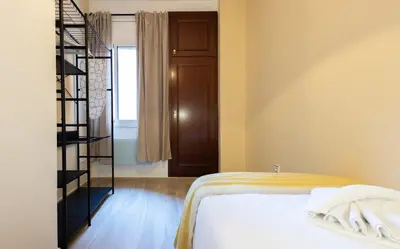 a bedroom with a bed and a spiral staircase at Stay U-nique Apartments Sant Nicolau in Barcelona