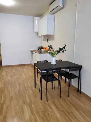 a black dining room table with chairs and a vase with flowers at SUITE apartamento in Barcelona