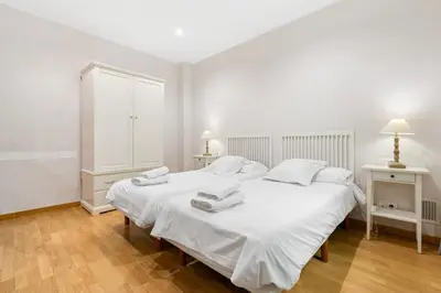 a white bedroom with a large white bed with towels on it at Flateli Pelayo H3 in Barcelona