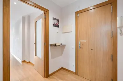 a hallway with a wooden door and a mirror at Flateli Pelayo H2 in Barcelona